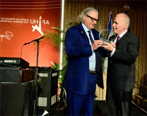 photo of one man presenting an award to another