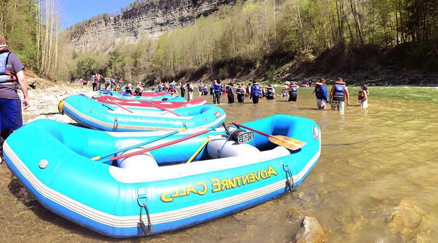 Inflatable rafts and students in a river