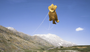 paper kite in the shape of a leopard floating in clear blue sky
